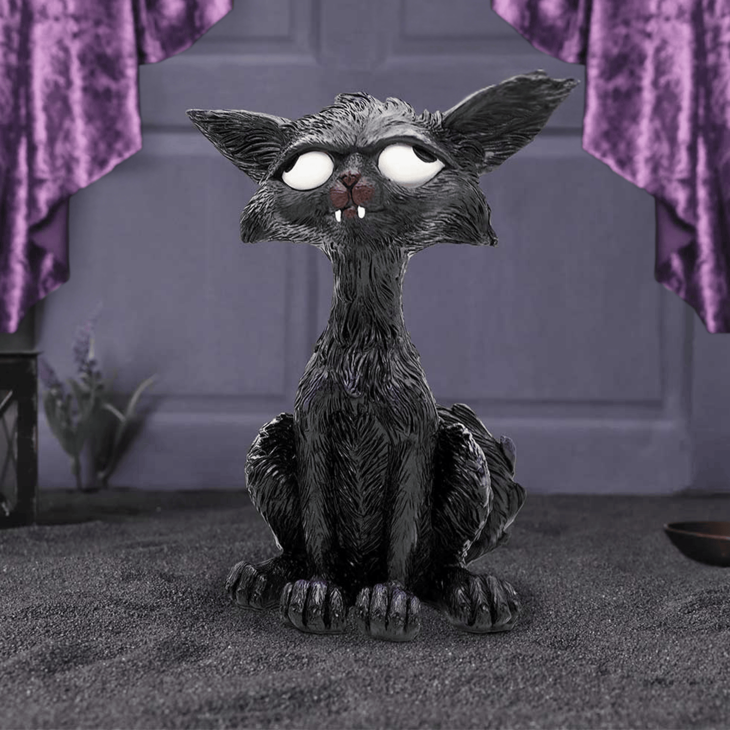 Gothic-style cat figurine with large eyes and pointed ears on a dark background