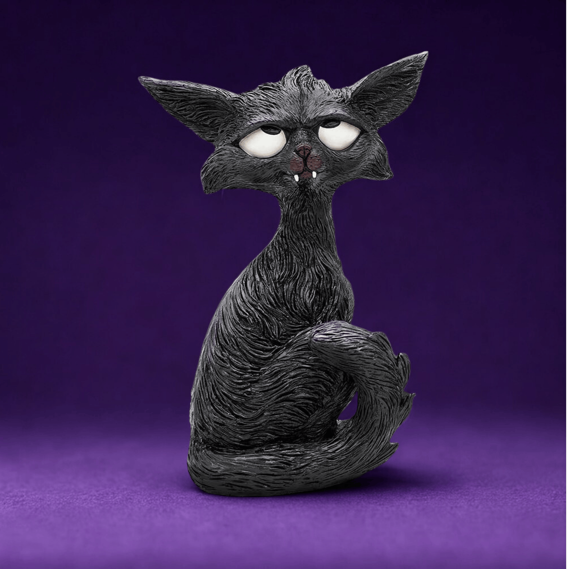 Black cat humorous figurine with white eyes looking up and little white fangs  on a purple background