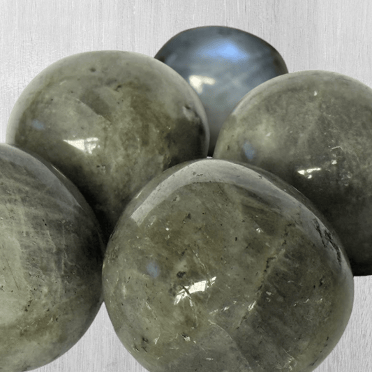 Close-up of polished Labradorite stones on a beige background