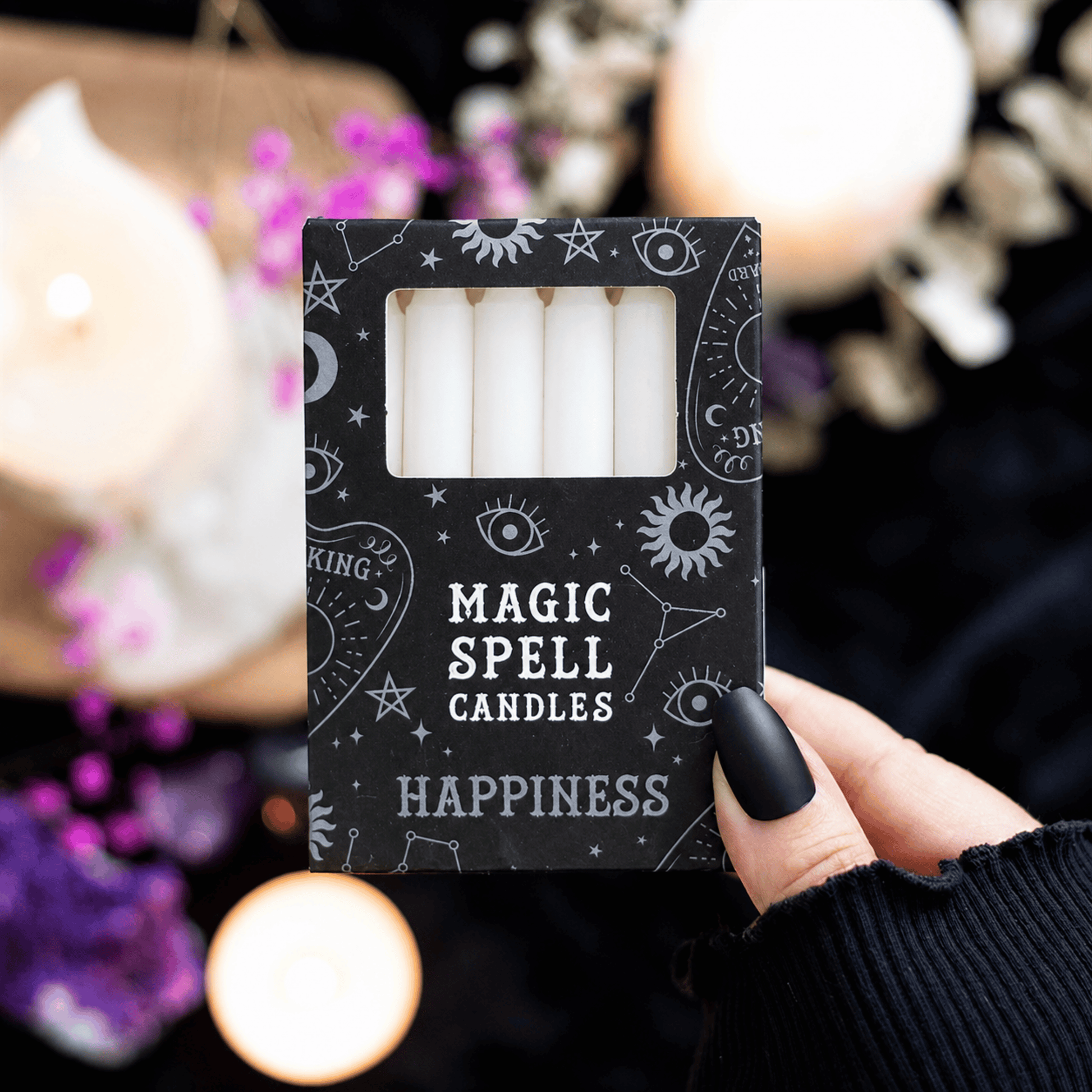Pack of 'Magic Spell Candles Happiness' with mystical symbols on a blurred background