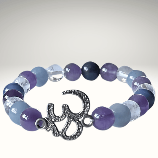 Multicolored beaded bracelet with a silver 'OM' charm on a gray background