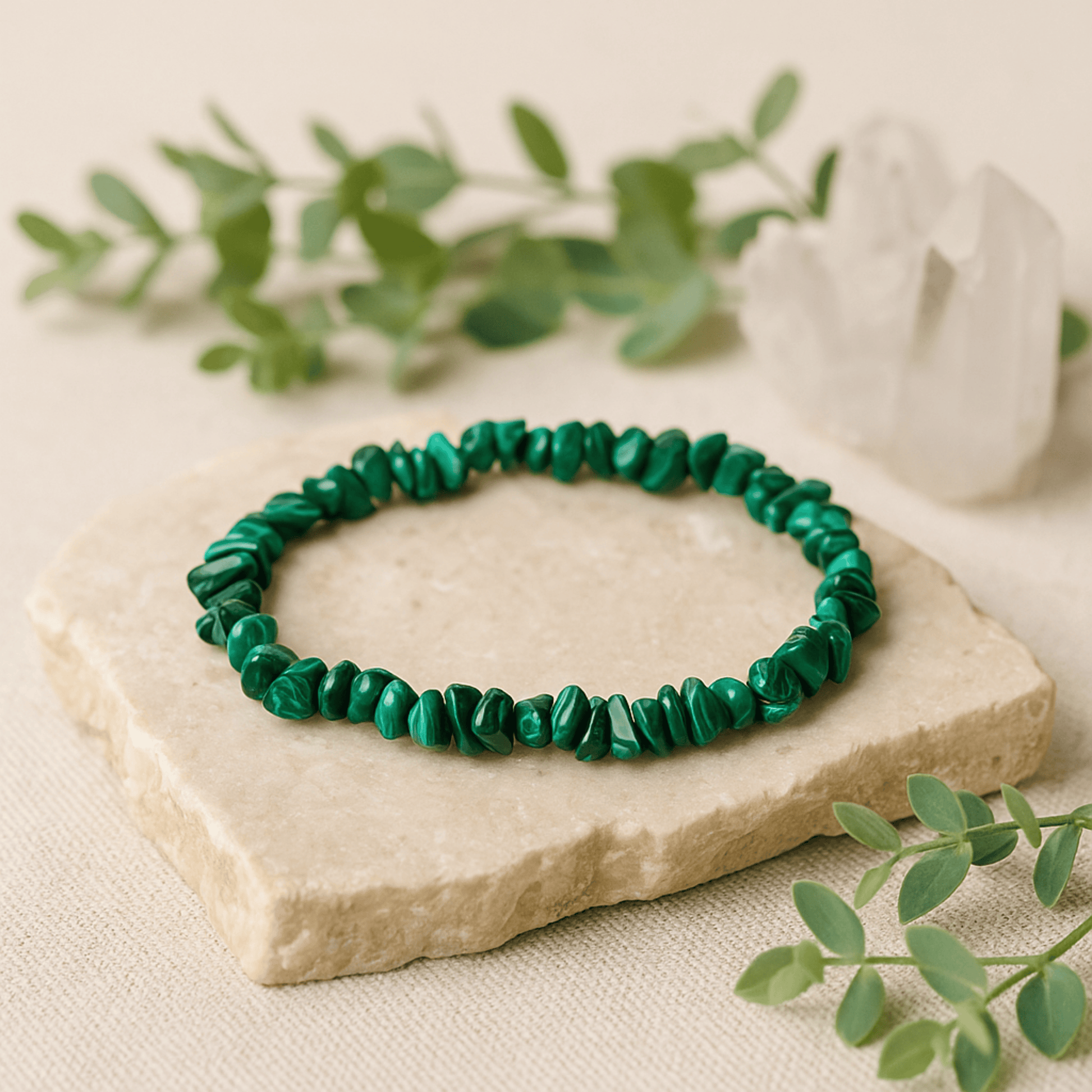 Green beaded bracelet on a stone surface with greenery in the background