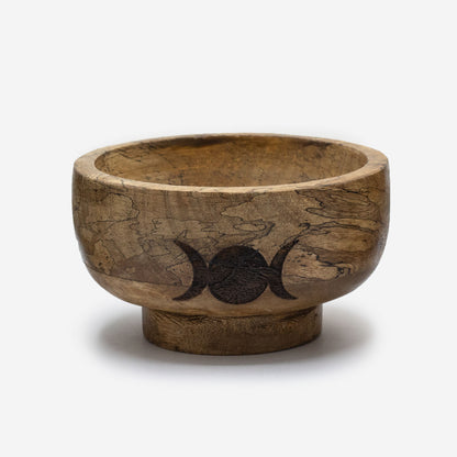 Wooden bowl with a moon phase design on a white background