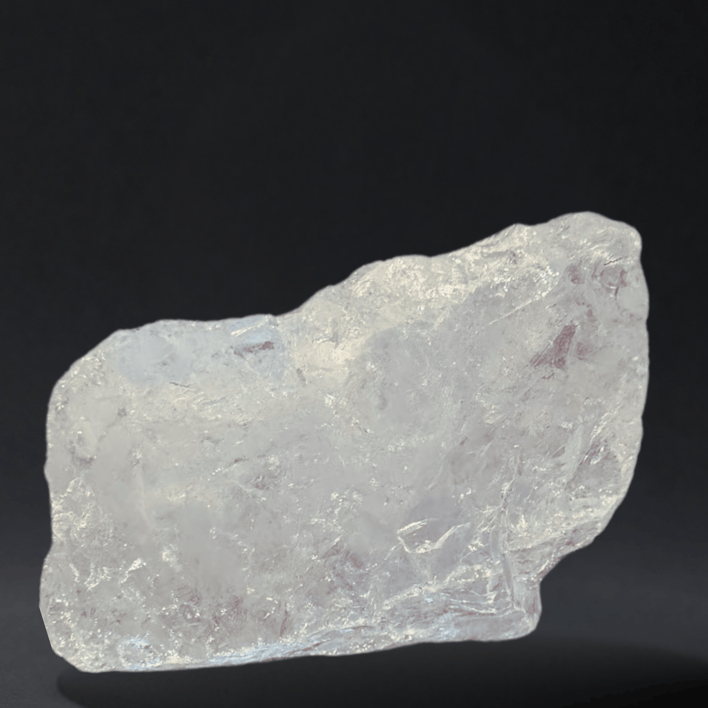 Raw clear quartz crystal on a black background