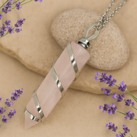 Necklace with pink rose quartz stone pendant on a beige background with lavender flowers