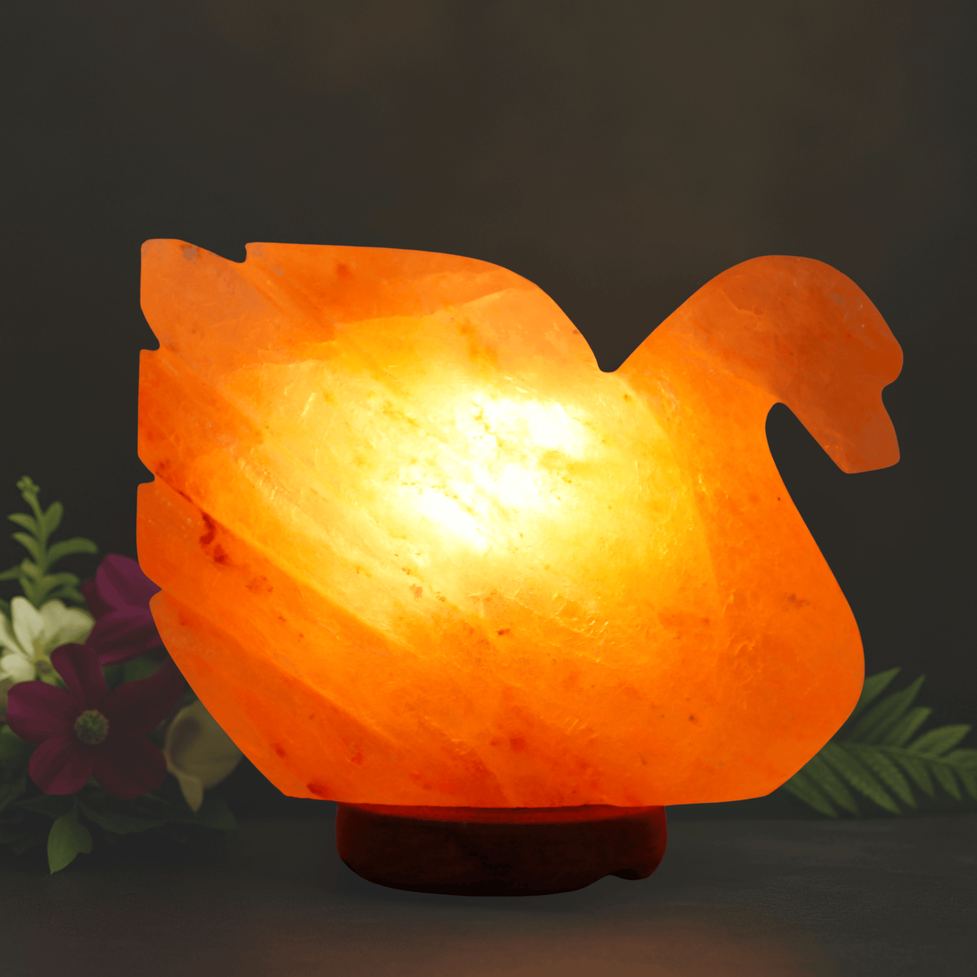 Orange swan-shaped lamp with a warm glow on a dark background