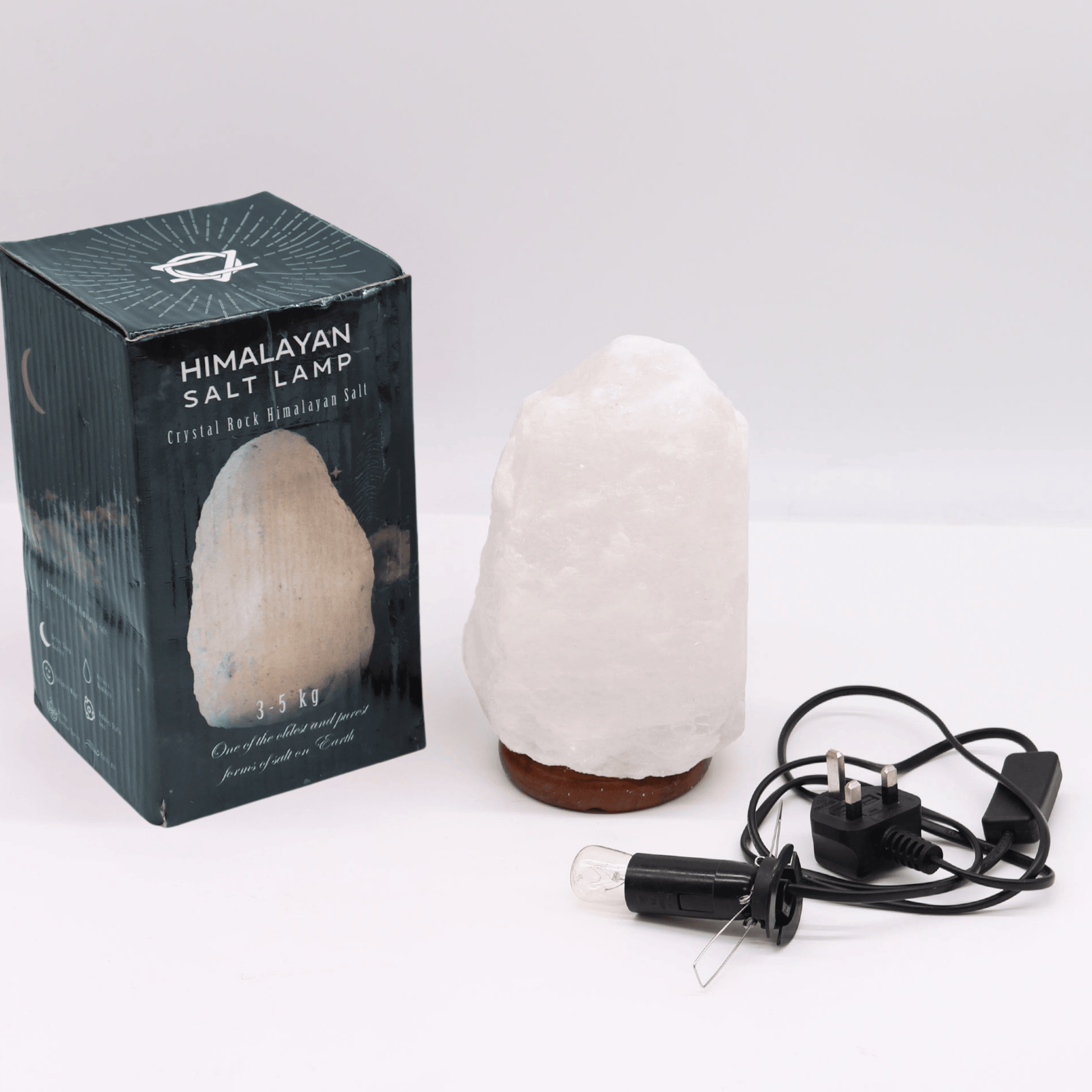 Himalayan salt lamp with packaging and plug on a white background