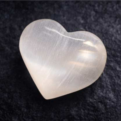 Heart-shaped Selenite Crystal on a dark textured background