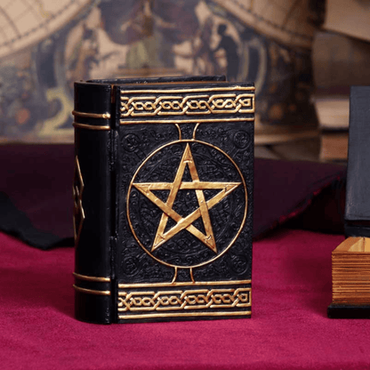 Black book box with gold pentagram design on a red surface