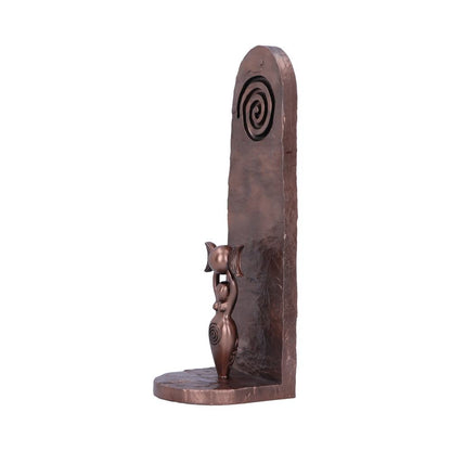 Side of the bronze sculptured incense holder of a Goddess holding a triple moon with spiral design on a textured bronze background