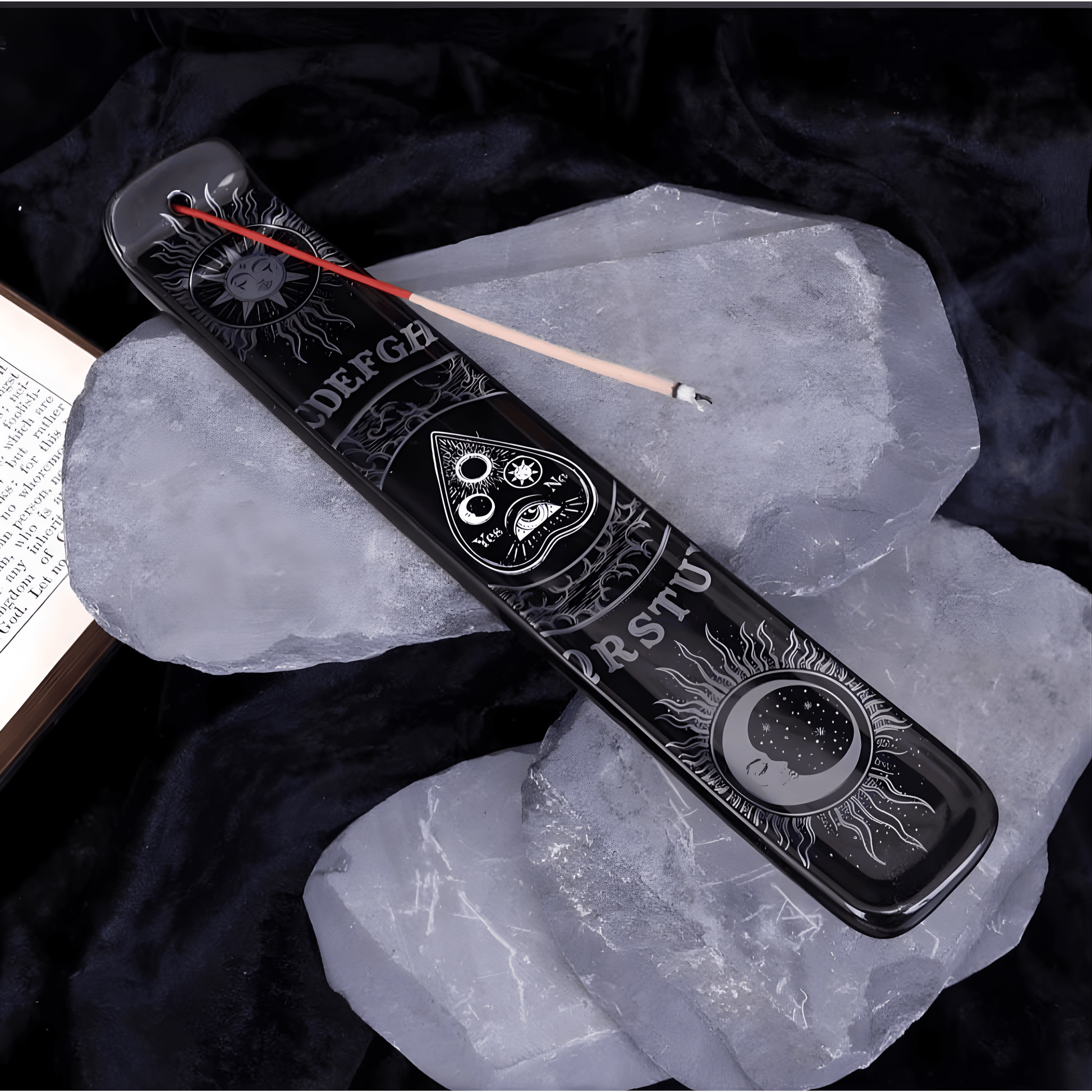 Decorative black incense holder with engraved symbols on a dark background