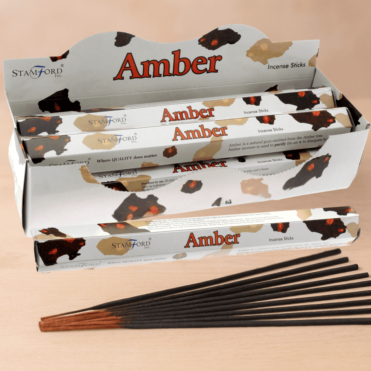 Amber incense sticks with packaging on a beige background