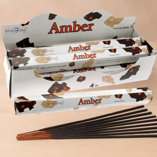 Amber incense sticks with packaging on a beige background