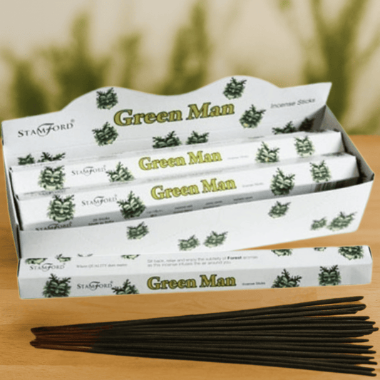 Box of Stamford Green Man incense sticks on a wooden surface with a blurred green background.