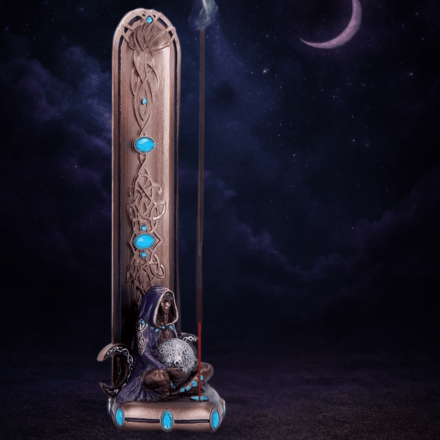 Decorative incense burner with mermaid figure and blue stones against a dark background