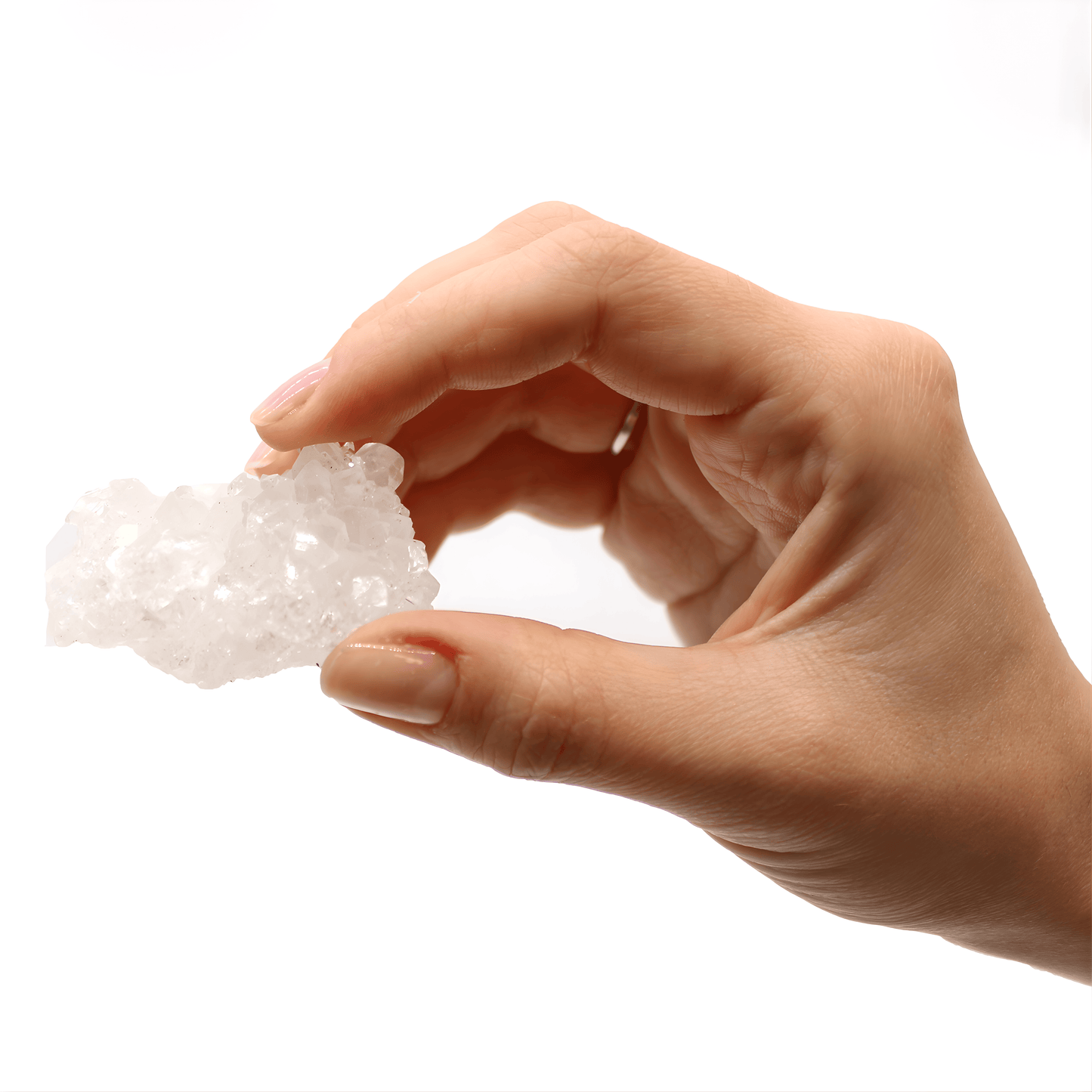 Hand holding a piece of crystal on a white background