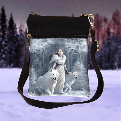 Shoulder bag with a design of a woman and two white wolves in a snowy forest.
