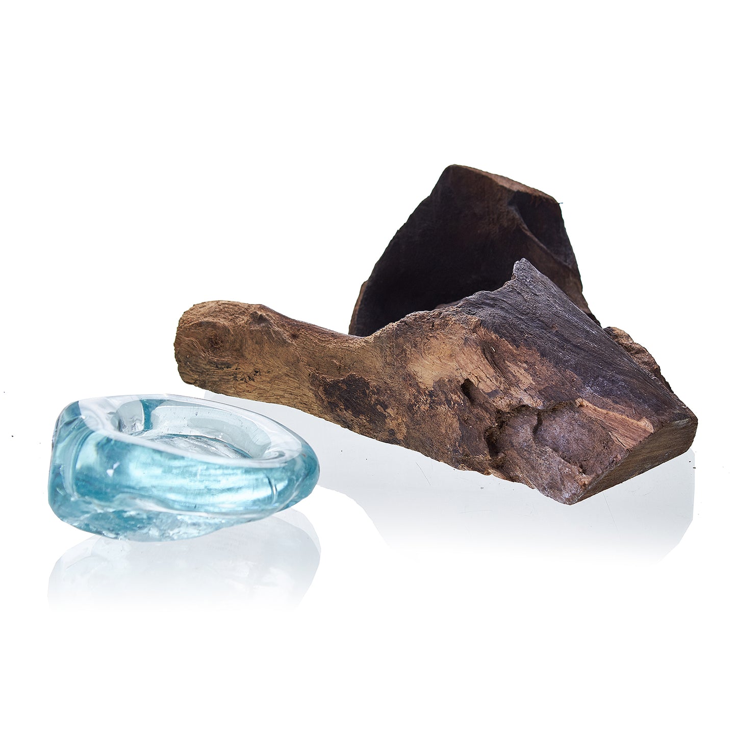 Driftwood and a clear blue glass object on a white background
